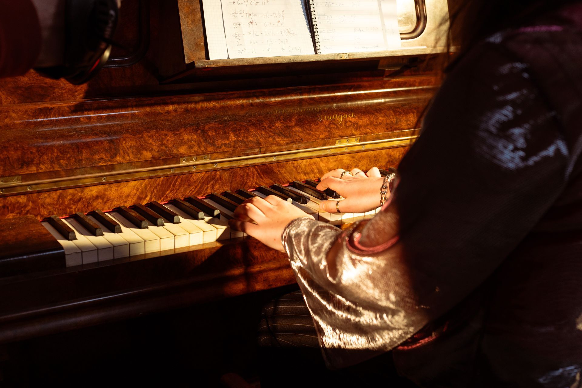 A person is playing a piano in a dark room.