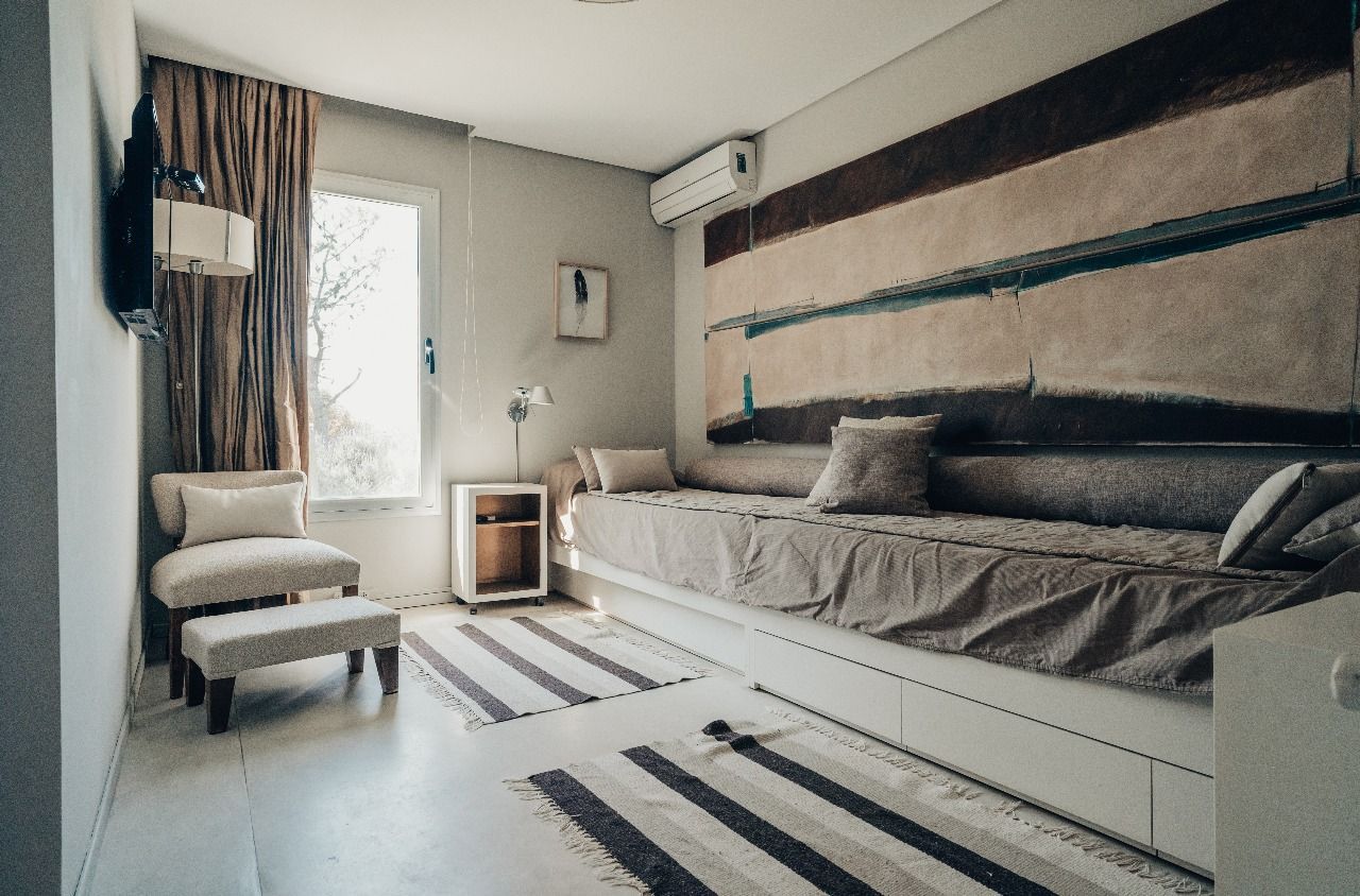 Un dormitorio con un sofá, una silla y una alfombra.