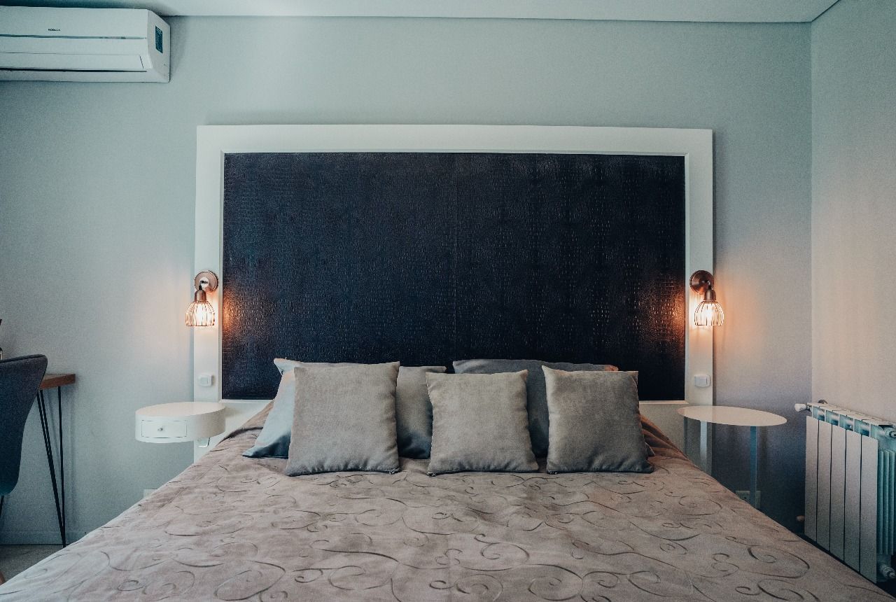 Una cama con cabecero y almohadas en un dormitorio.