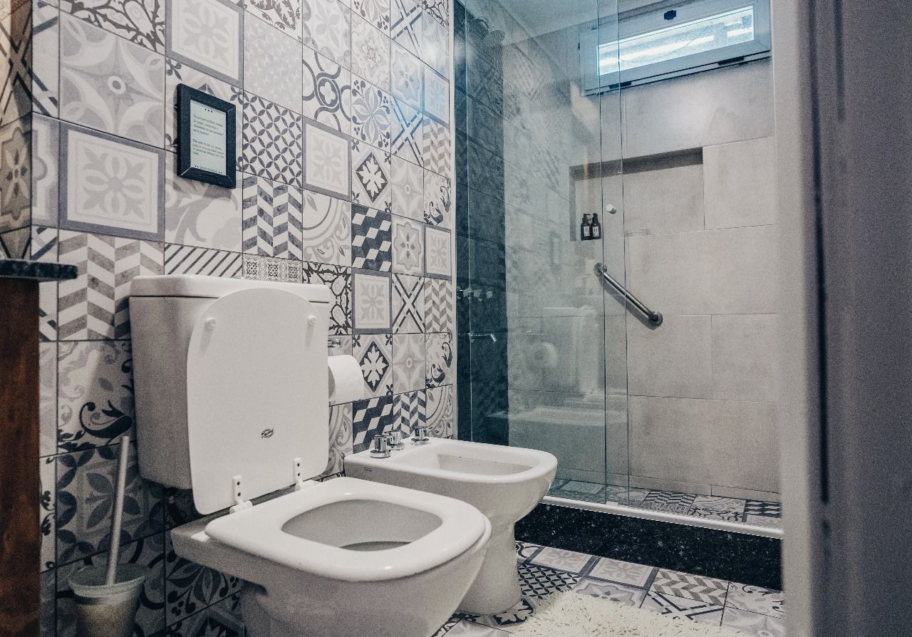 Un baño con dos inodoros y un bidé.