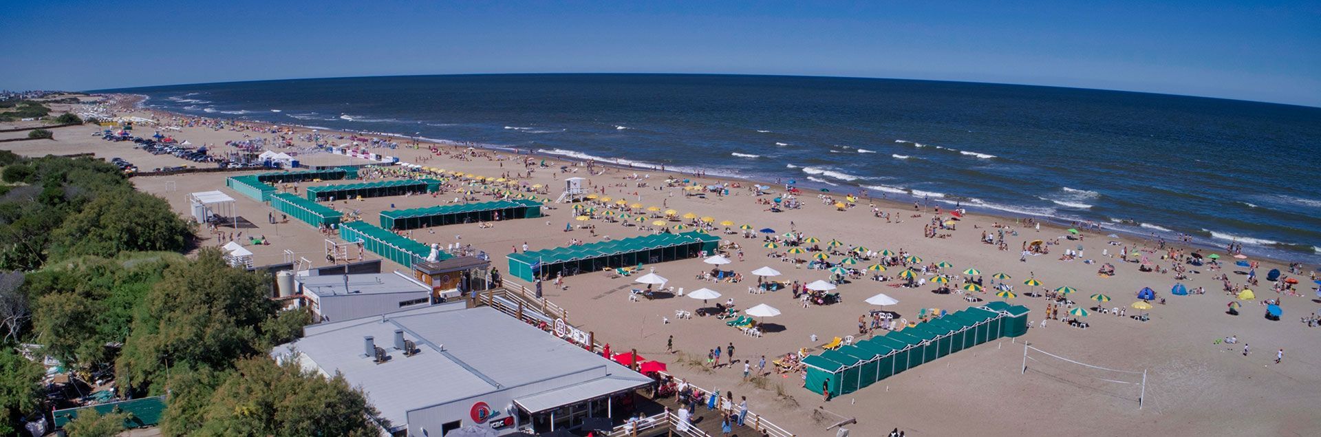 Una vista aérea de una playa llena de gente y sombrillas.