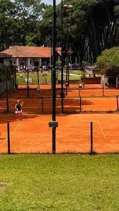 Un grupo de personas está jugando al tenis en una cancha de tenis.