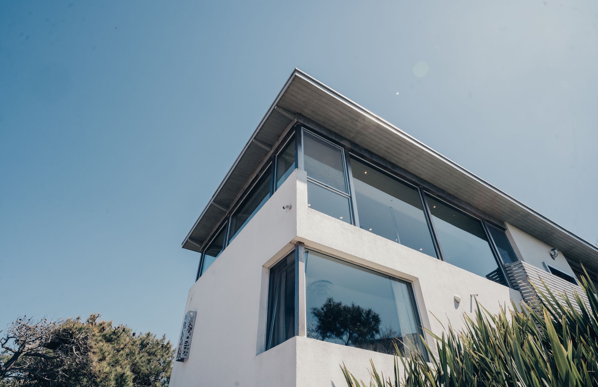 Una casa grande blanca con muchas ventanas y un balcón.