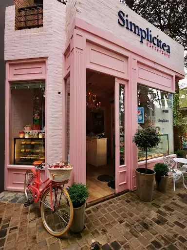 Un edificio rosa y blanco con una bicicleta estacionada enfrente.