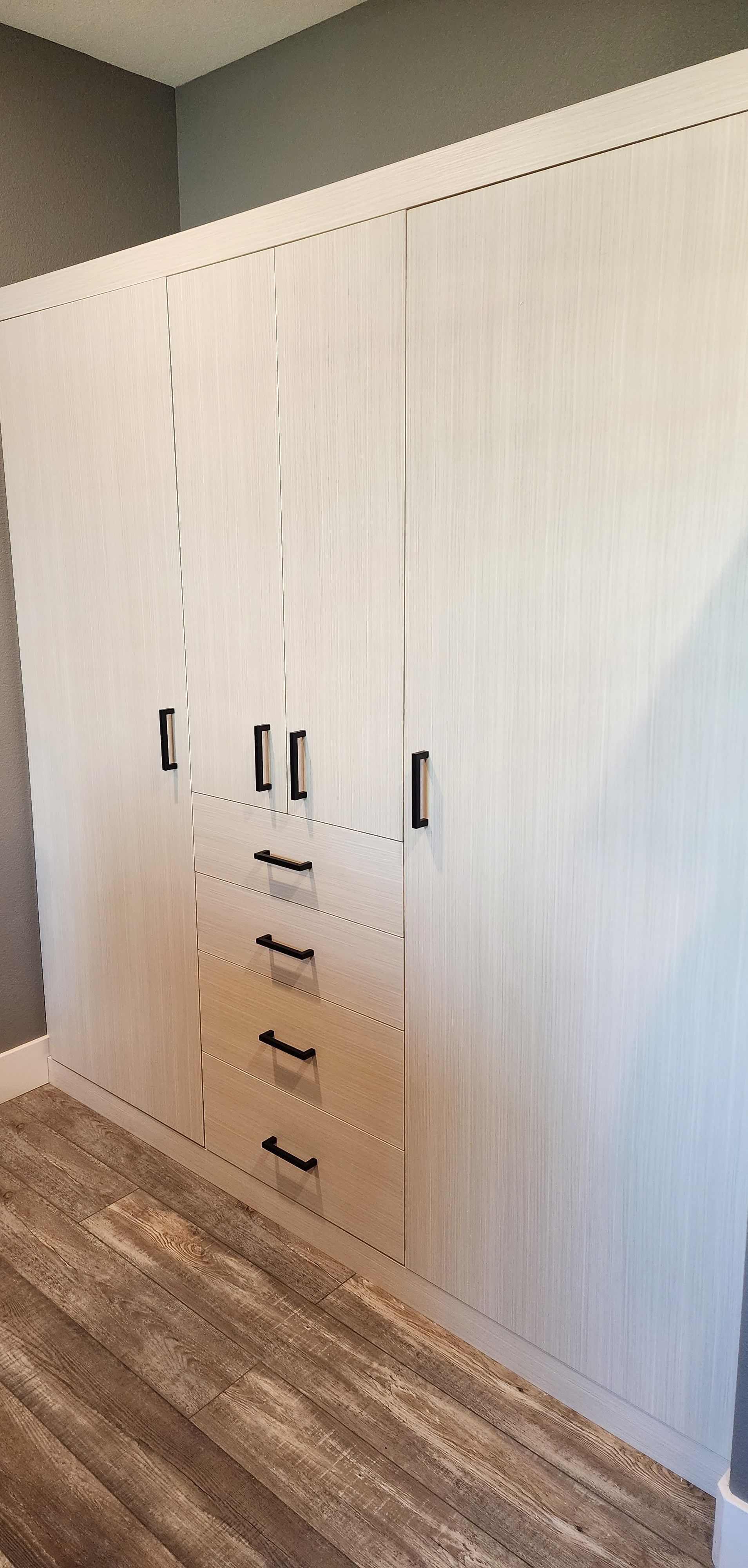 A room with a lot of cabinets and drawers on the wall.
