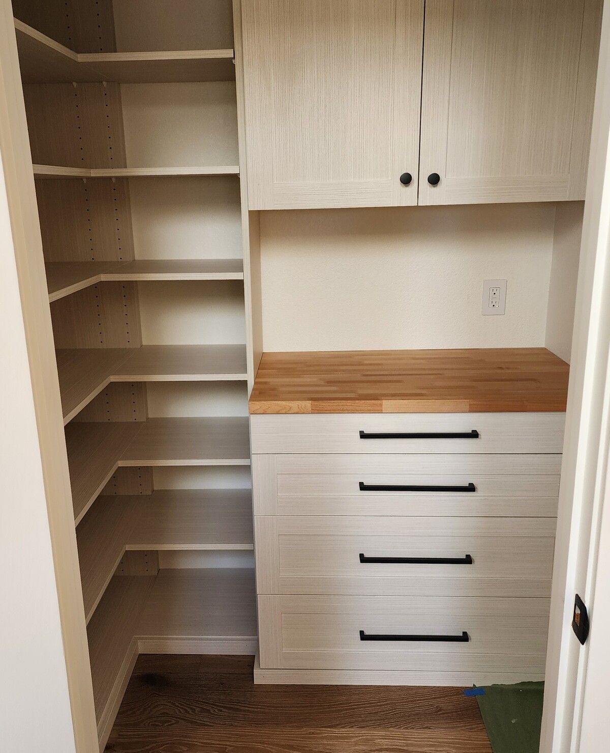 A closet with shelves and drawers and a wooden counter top