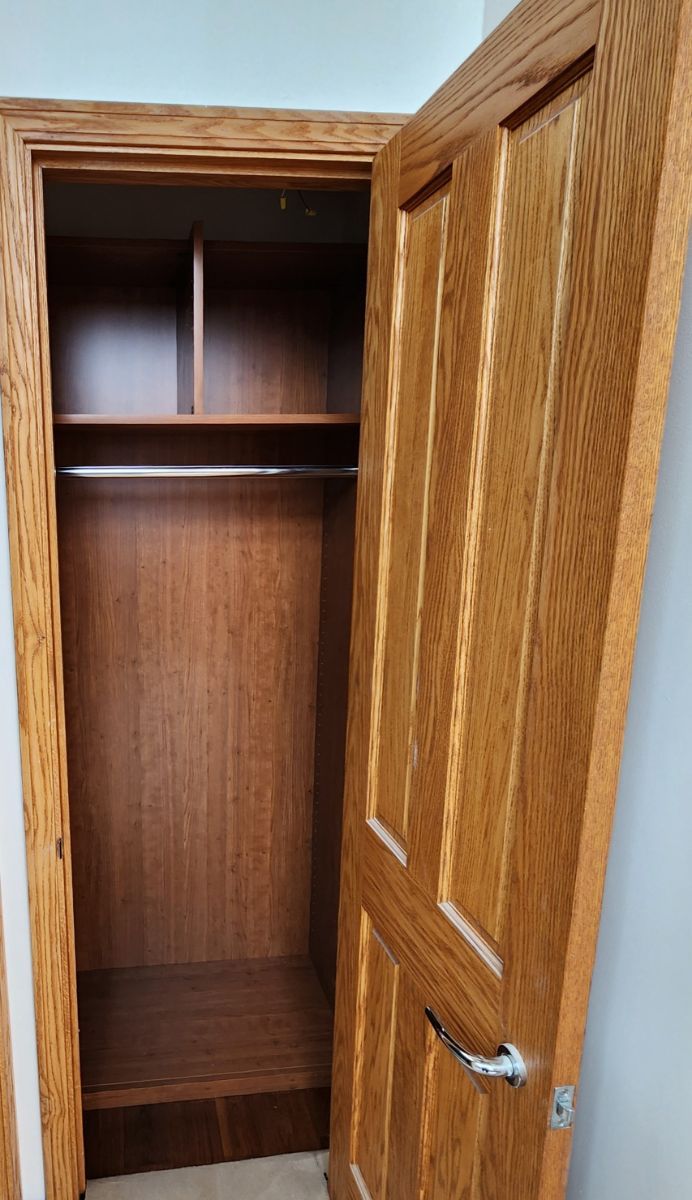 An empty wooden closet with the door open