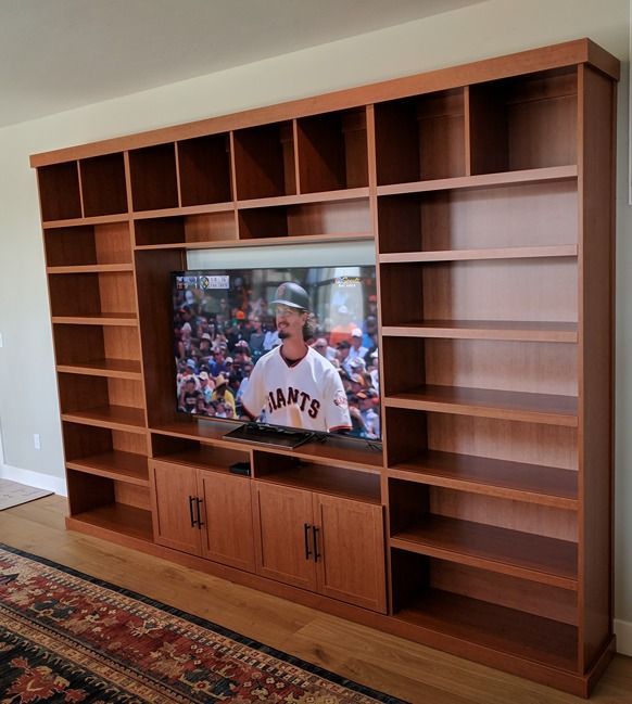A man in a giants jersey is watching a baseball game
