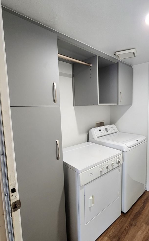 A laundry room with a washer and dryer and cabinets.
