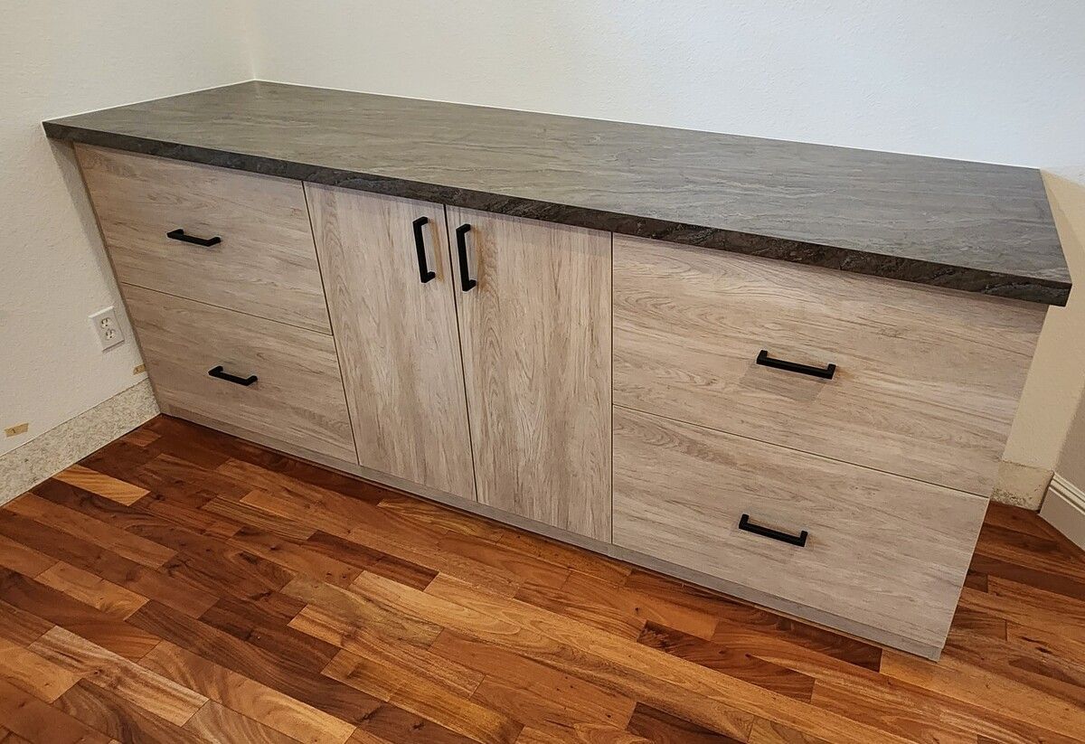 A wooden dresser with drawers and cabinets is sitting on a wooden floor in a room.