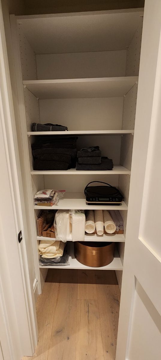 A closet filled with shelves and clothes and a door.