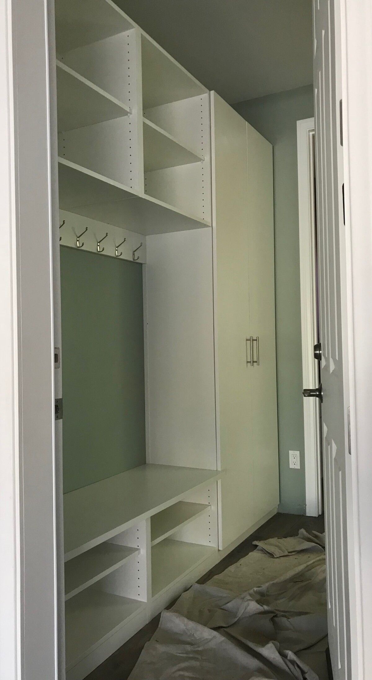 A hallway with a lot of shelves and a door.