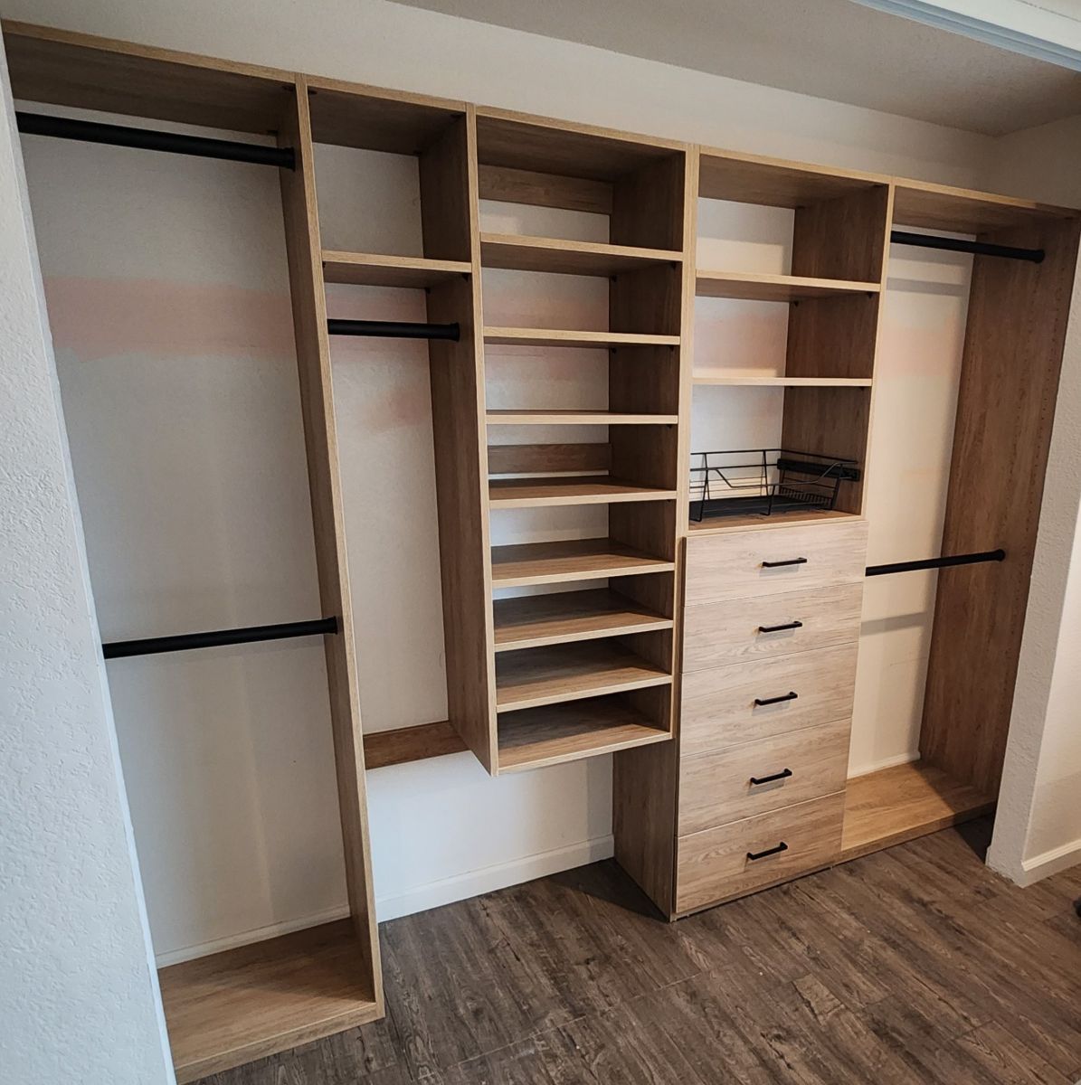 A walk in closet with lots of shelves and drawers.
