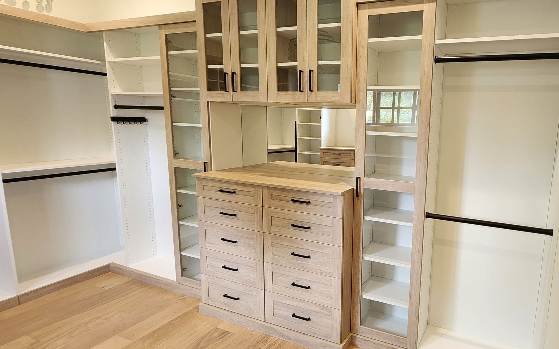 A walk in closet with lots of shelves and drawers.