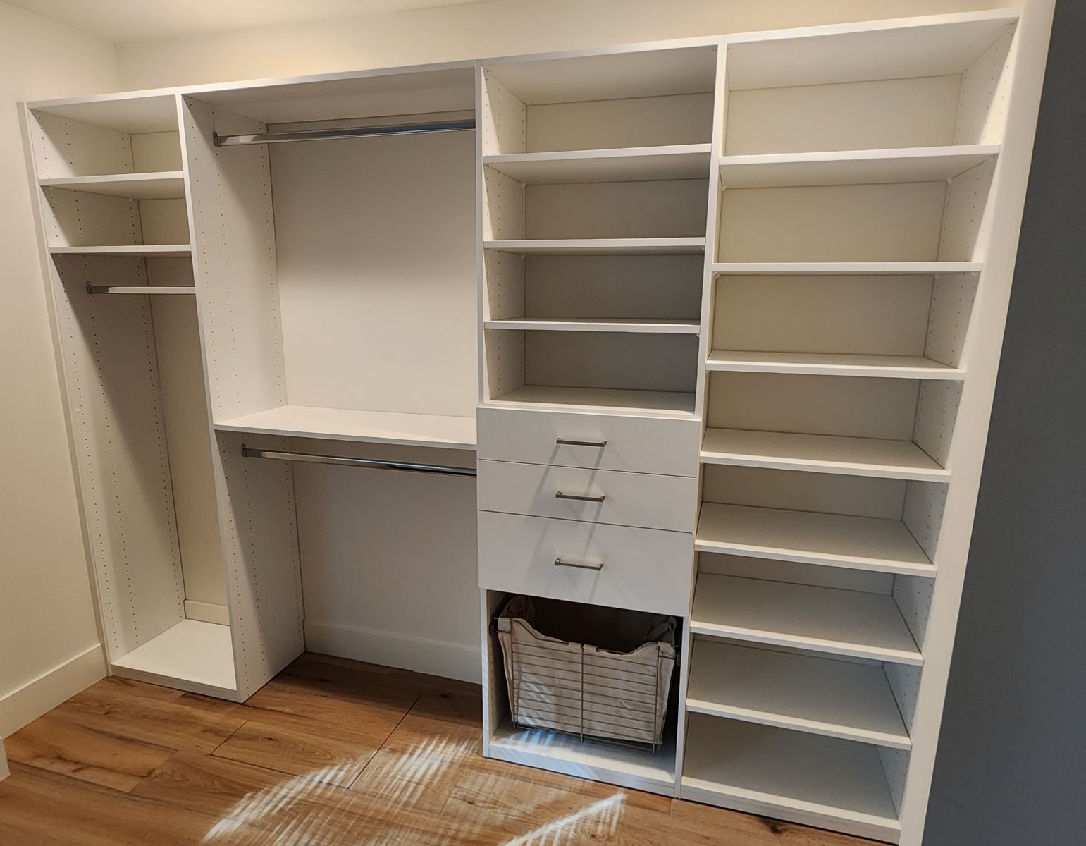 A walk in closet with lots of shelves and drawers.