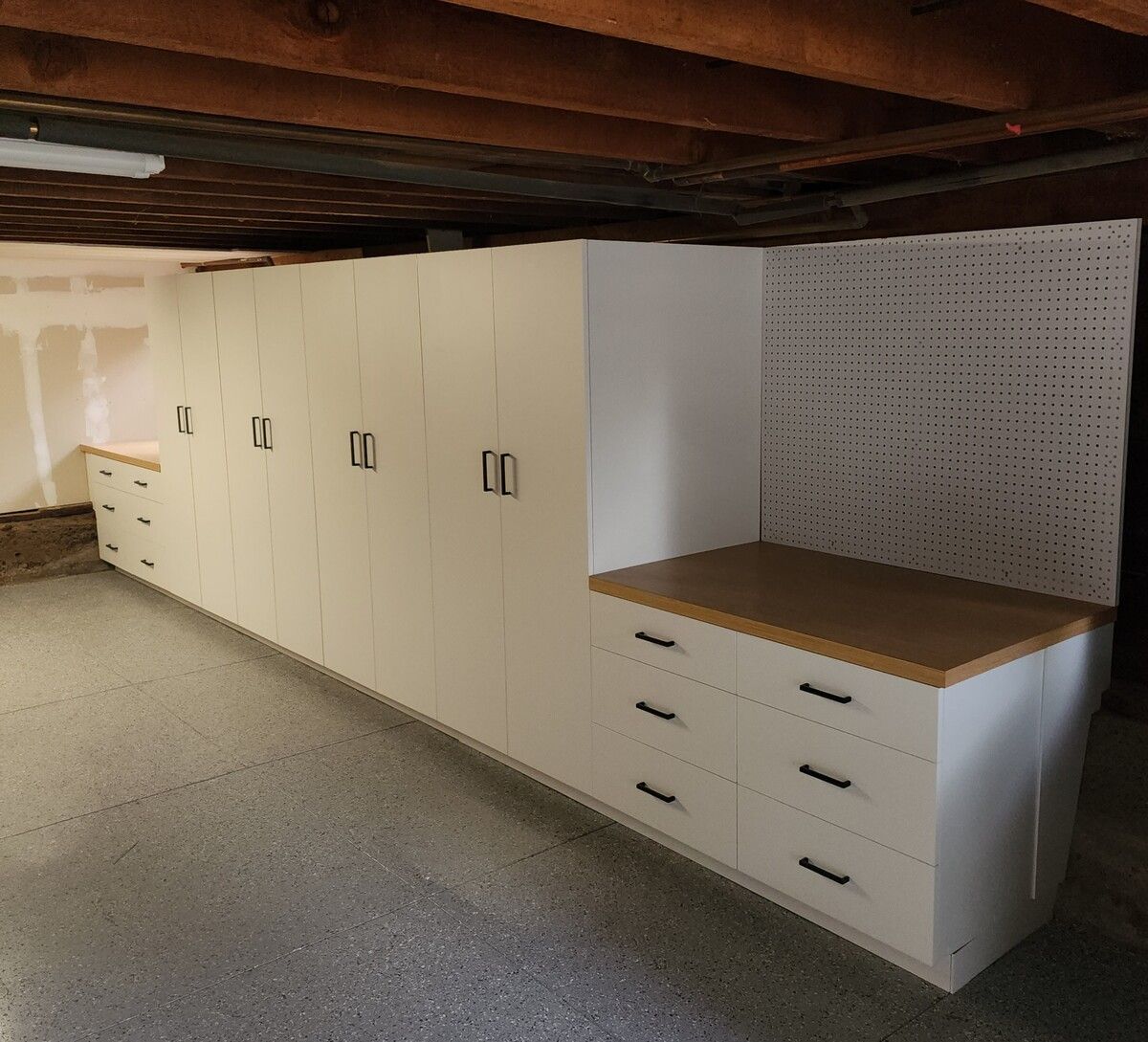 A room with a lot of white cabinets and drawers
