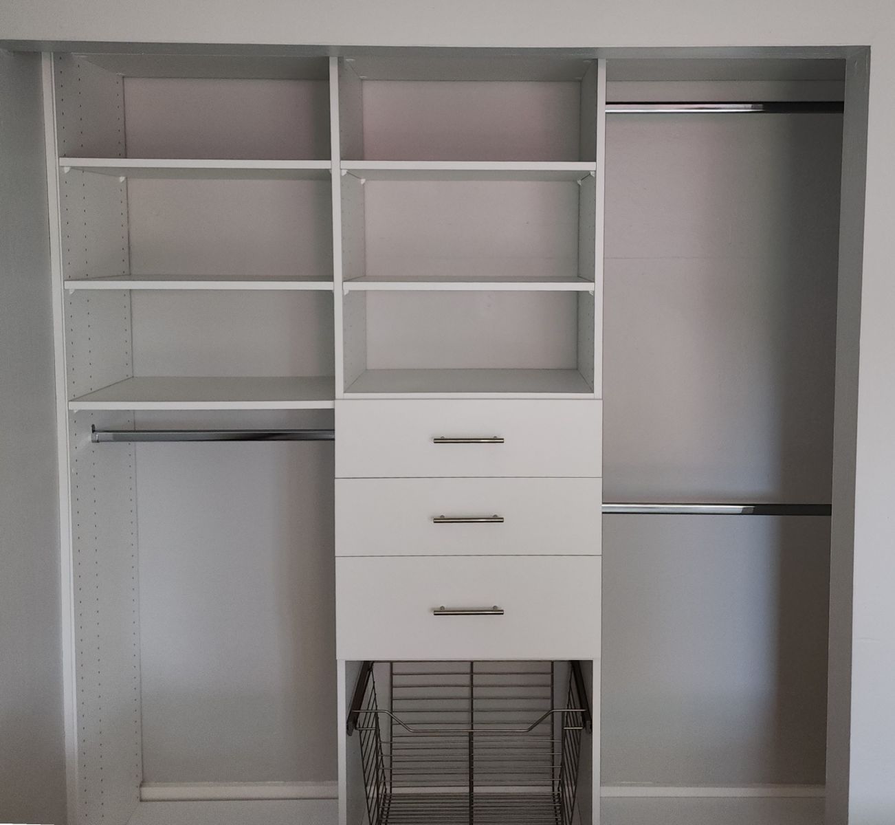 A closet with shelves , drawers , and a wire basket.