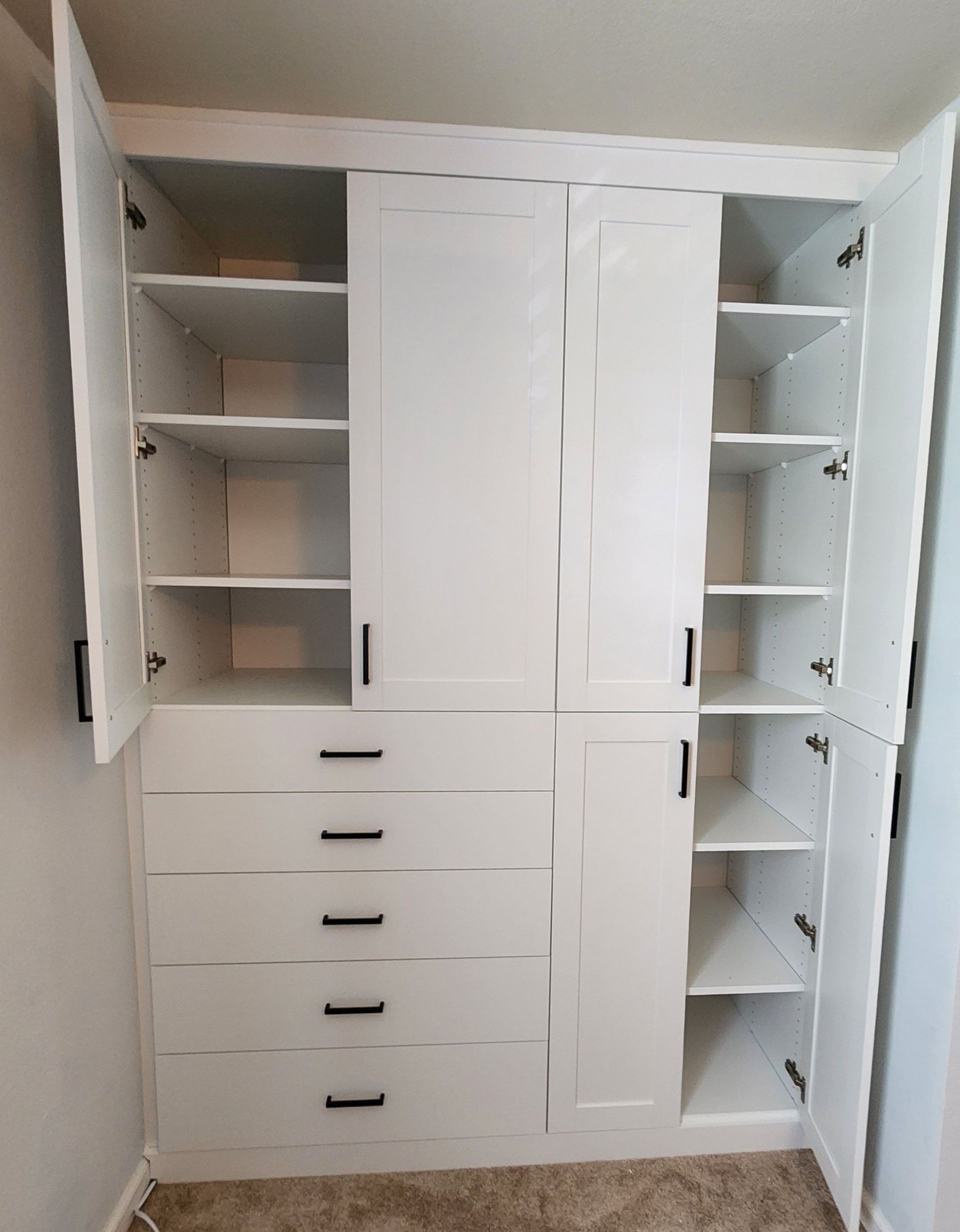 A white closet with the doors open and shelves.