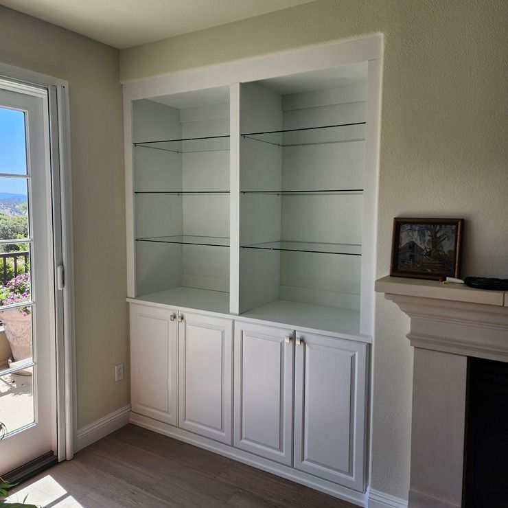 A living room with white cabinets and a fireplace