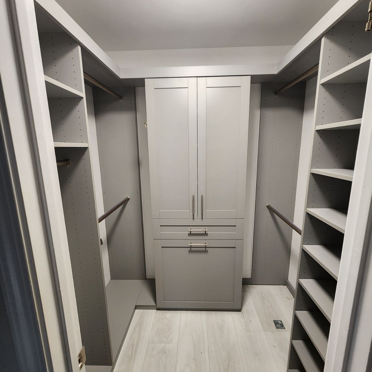 A walk in closet with lots of shelves and drawers