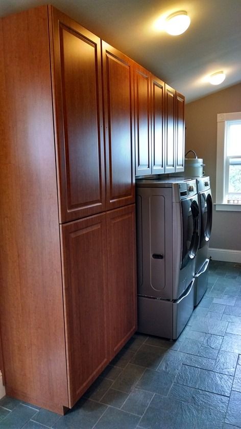 A laundry room with a washer and dryer and lots of cabinets.