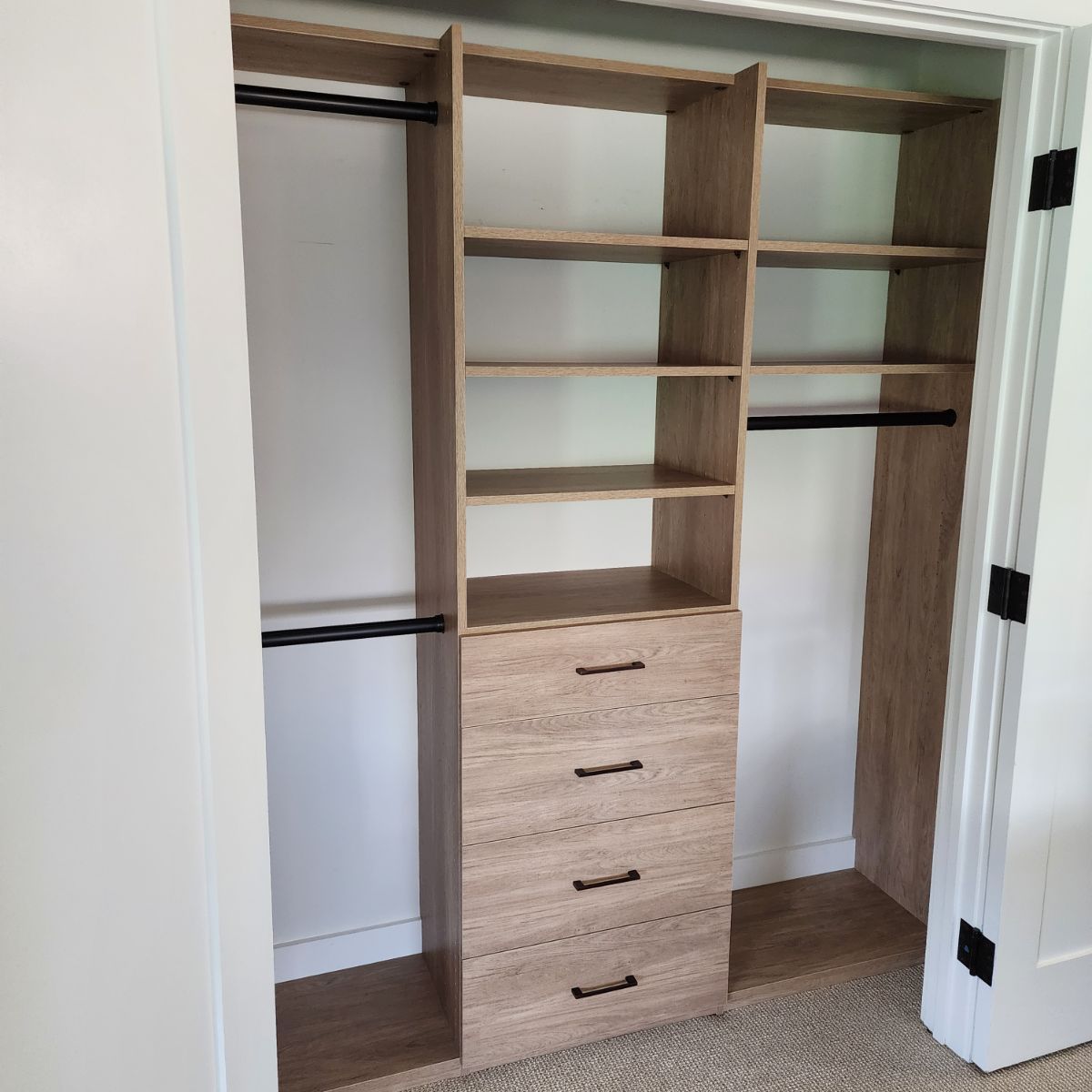 A closet with wooden shelves and drawers in a bedroom.