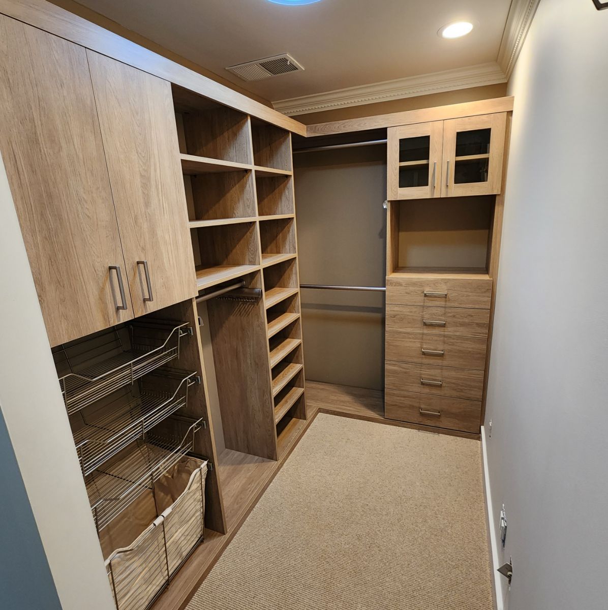 A walk in closet with lots of shelves and drawers