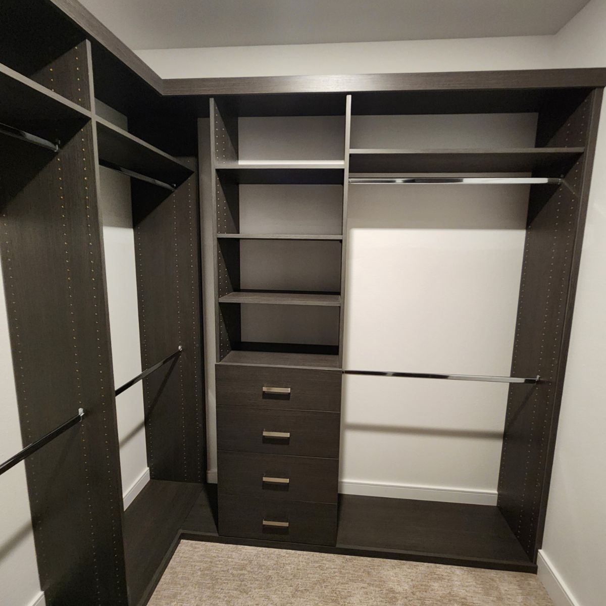 A walk in closet with lots of shelves and drawers