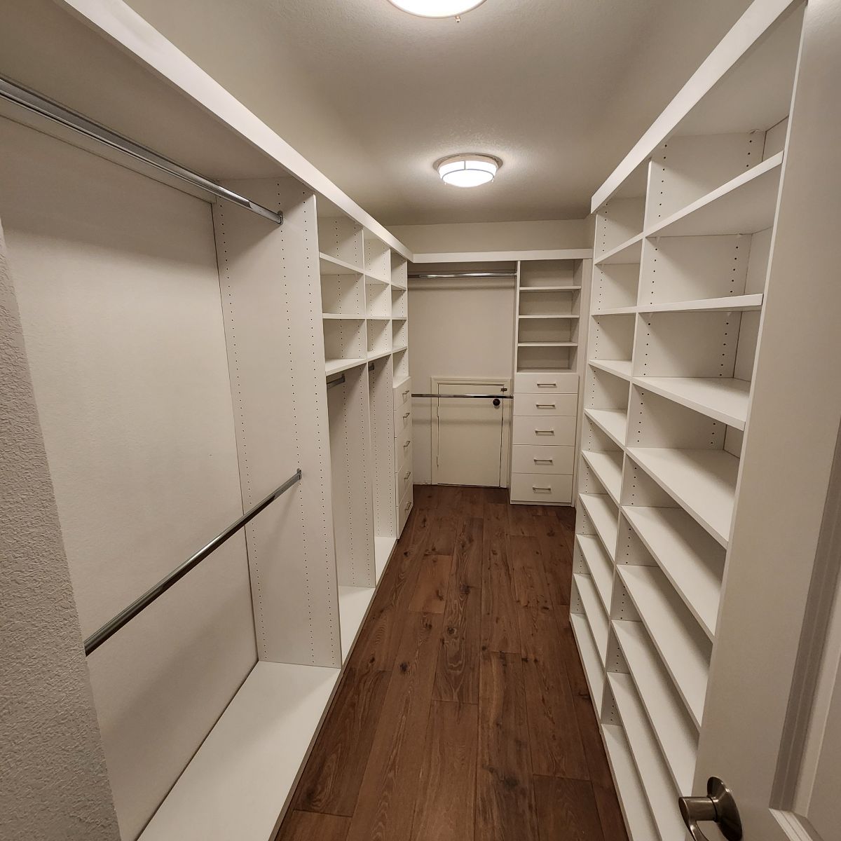 White walk-in closet with shelves and rods, hardwood floor, and recessed lighting.