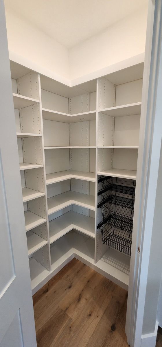 A walk in pantry with lots of shelves and a wine rack.