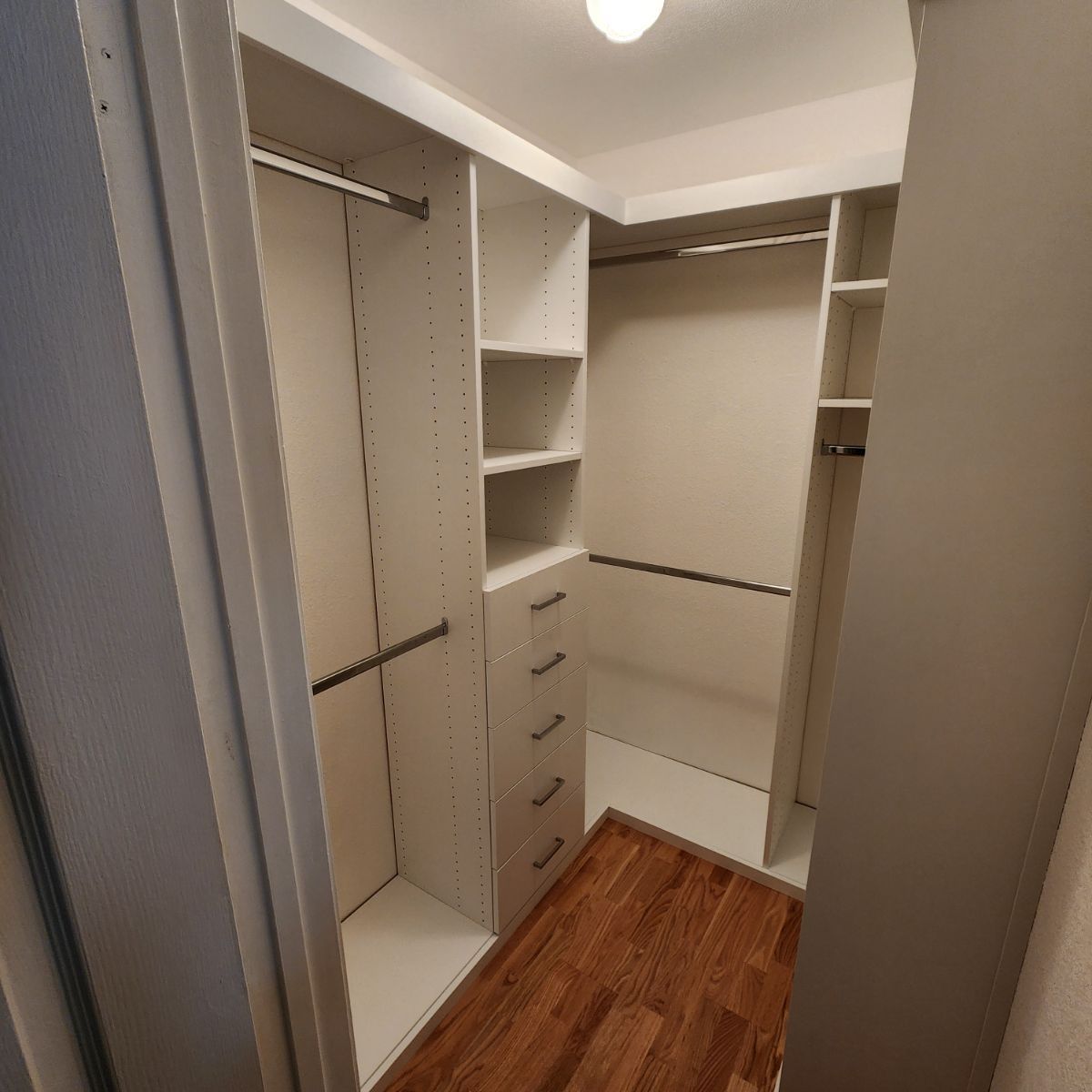 A walk in closet with lots of shelves and drawers