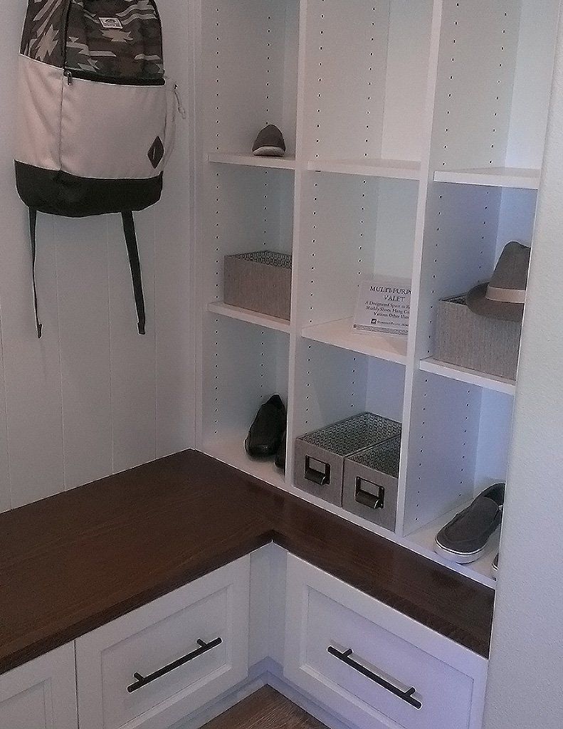 A room with shelves and a bench and a backpack on the wall