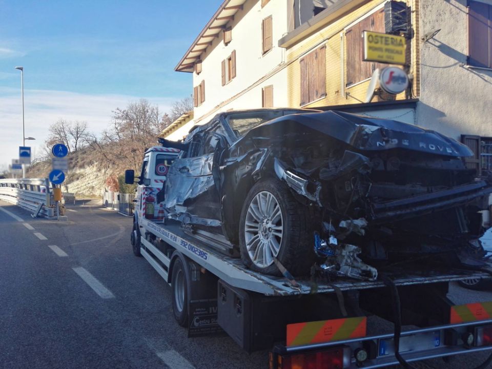 Un'auto distrutta viene trainata da un carro attrezzi