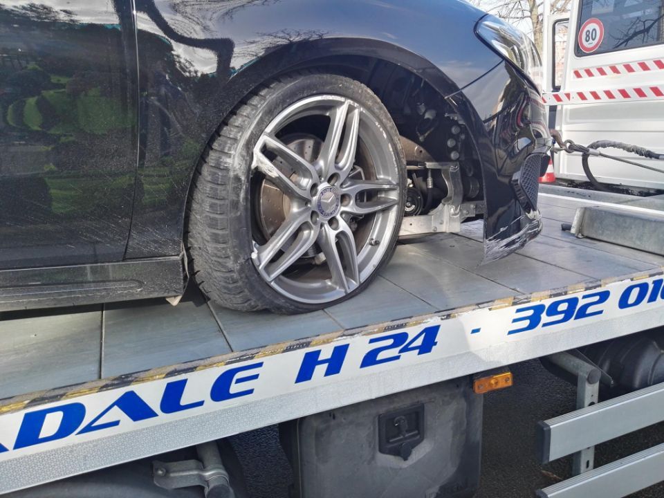 Un'auto nera è parcheggiata sopra un carro attrezzi.