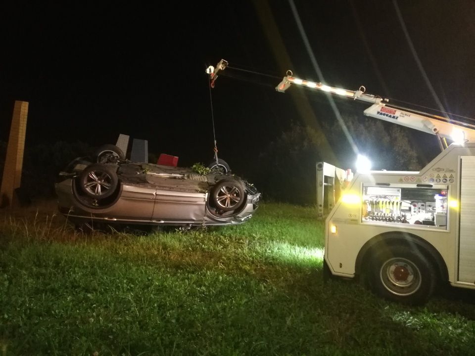 Un'auto viene trainata da un carro attrezzi di notte.