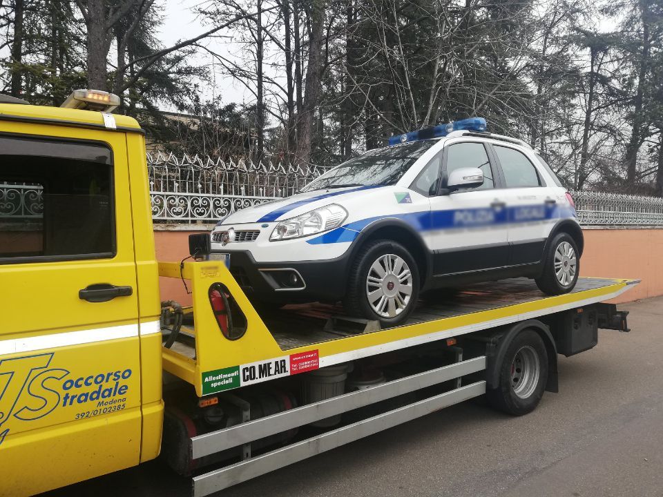 Un'auto viene trainata da un carro attrezzi giallo.