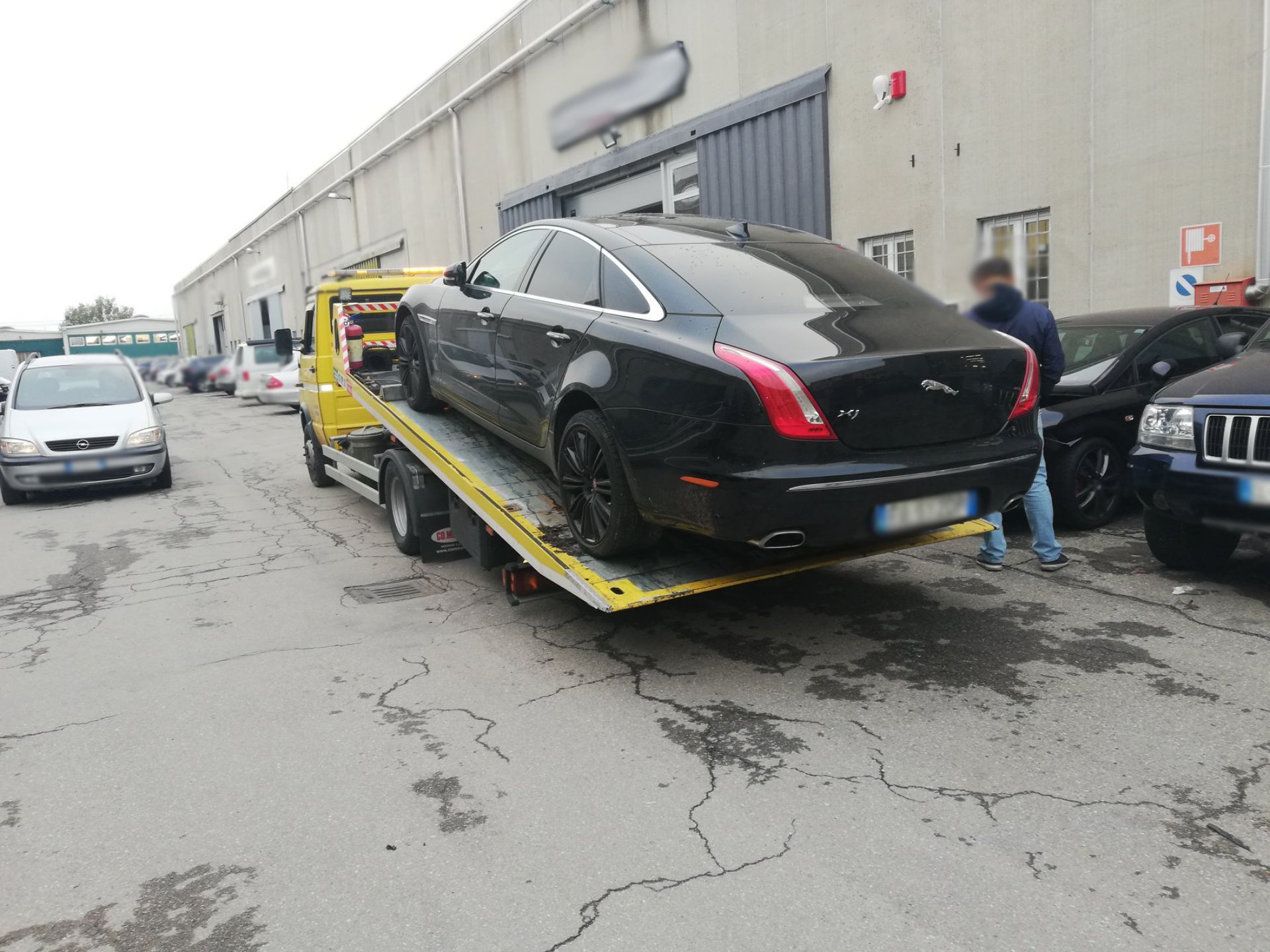 Un'auto nera viene trainata da un carro attrezzi giallo
