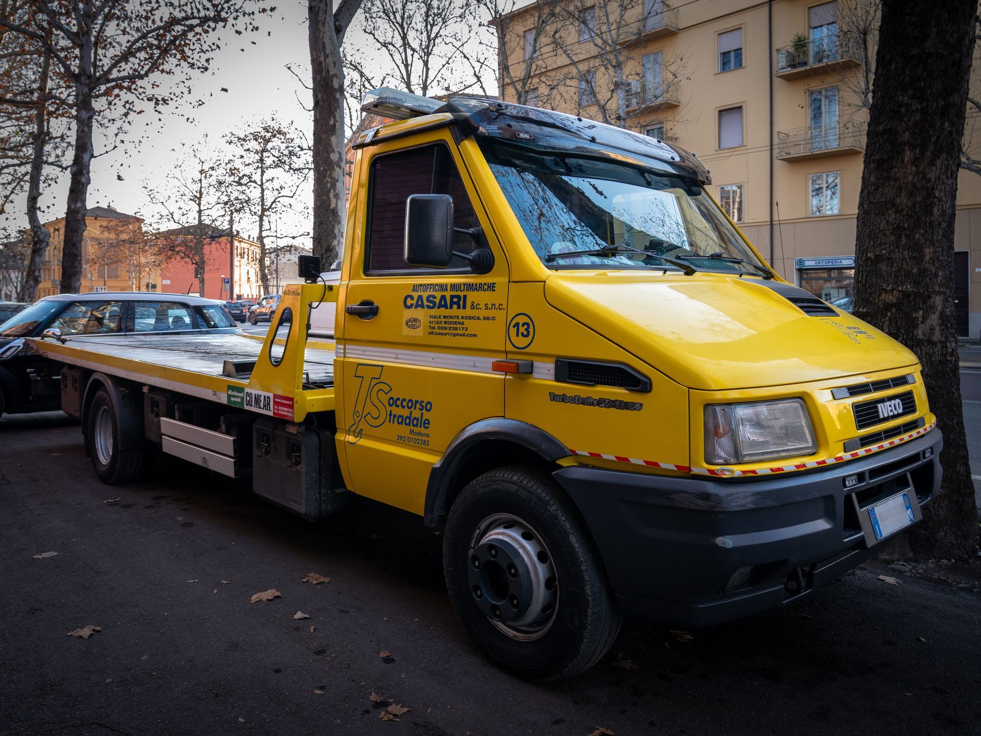 Un carro attrezzi giallo è parcheggiato sul ciglio della strada