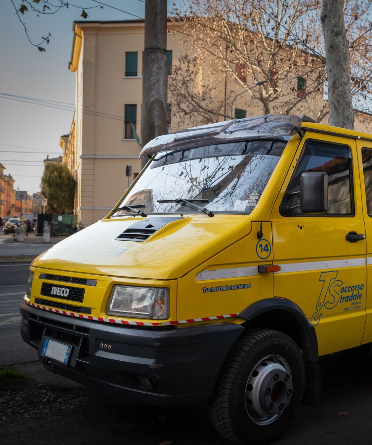 Un furgone Iveco giallo è parcheggiato sul ciglio della strada
