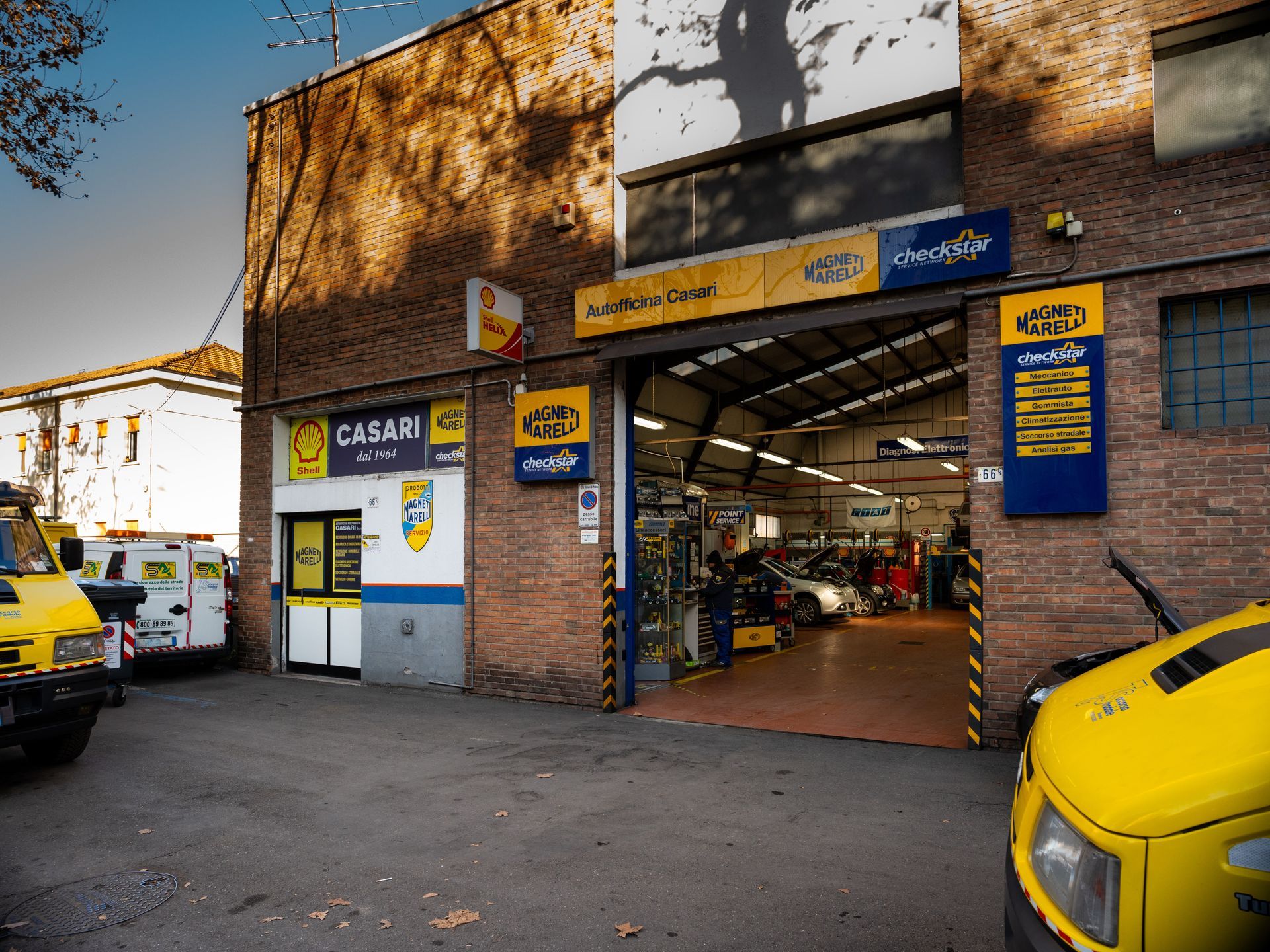 Un'auto gialla è parcheggiata davanti a un edificio con la scritta Casari