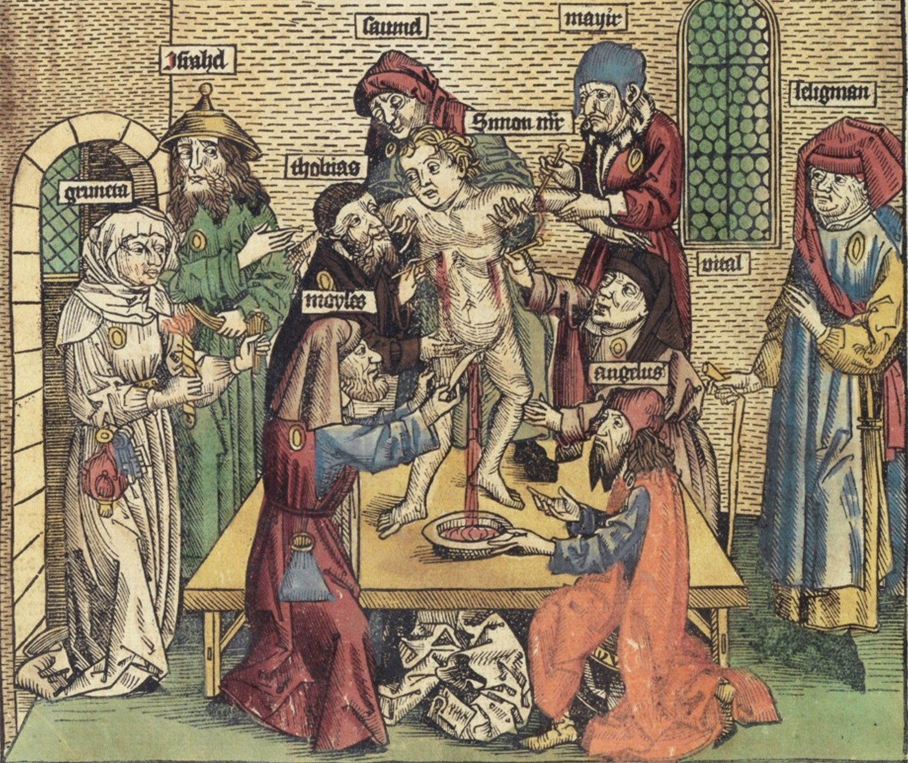 a group of people are gathered around a table bleeding a child