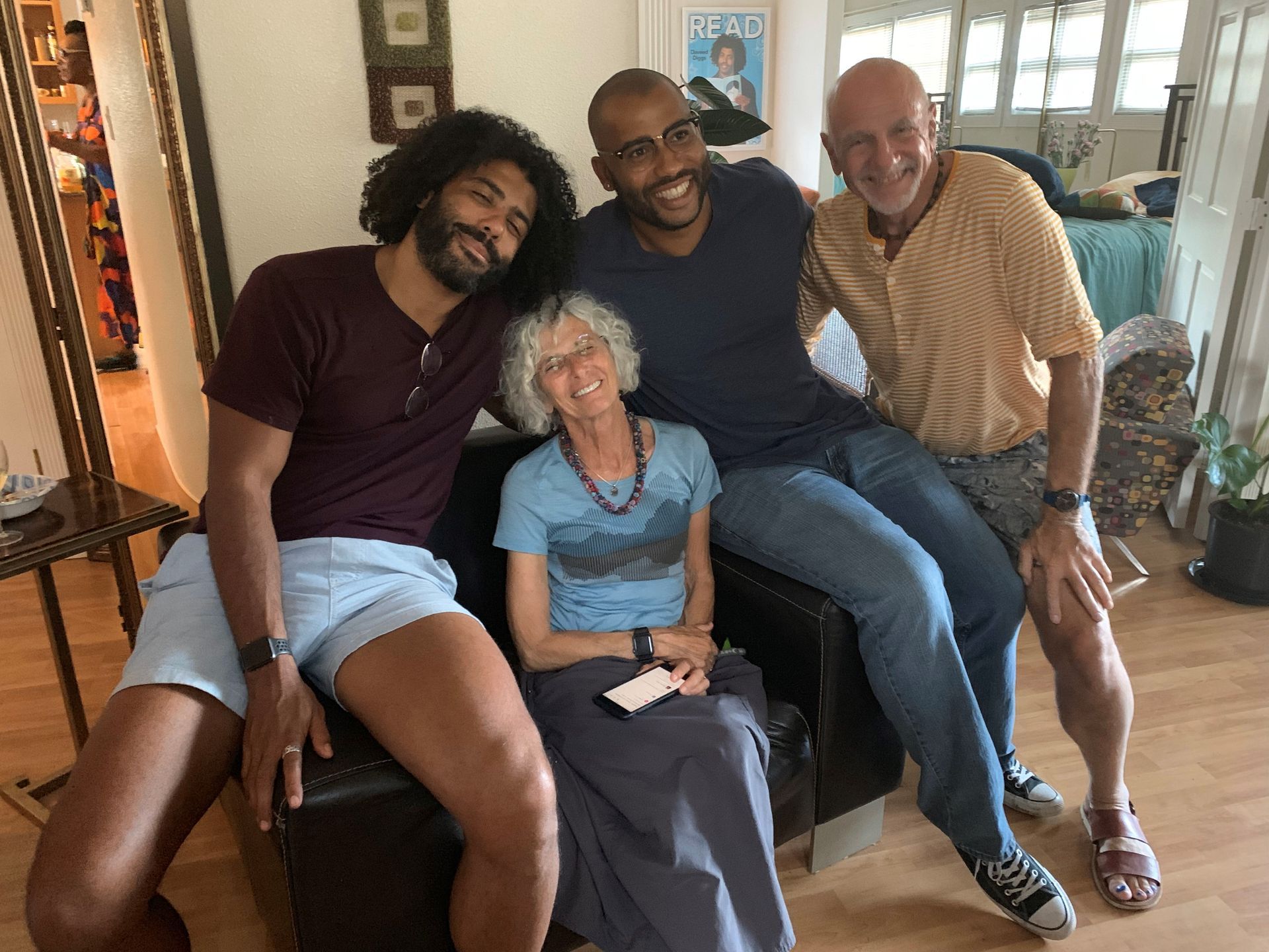 A group of people are posing for a picture while sitting on a couch.