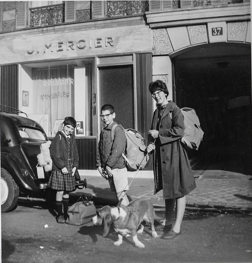 A black and white photo of people and a dog in front of a store called j. mercier robert philipson