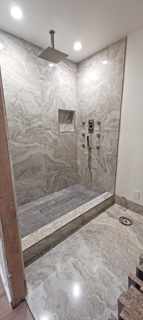 A bathroom with a walk in shower and a ceiling fan.