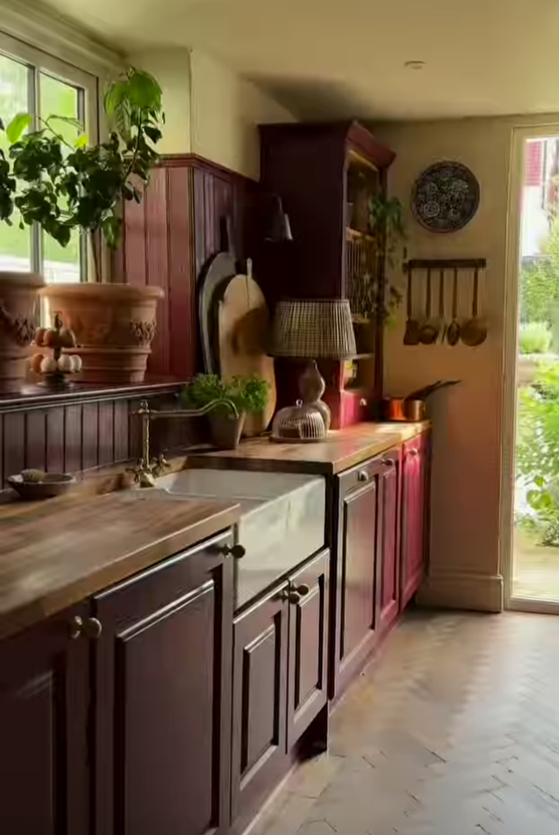 A kitchen with a sink , cabinets , and a window.