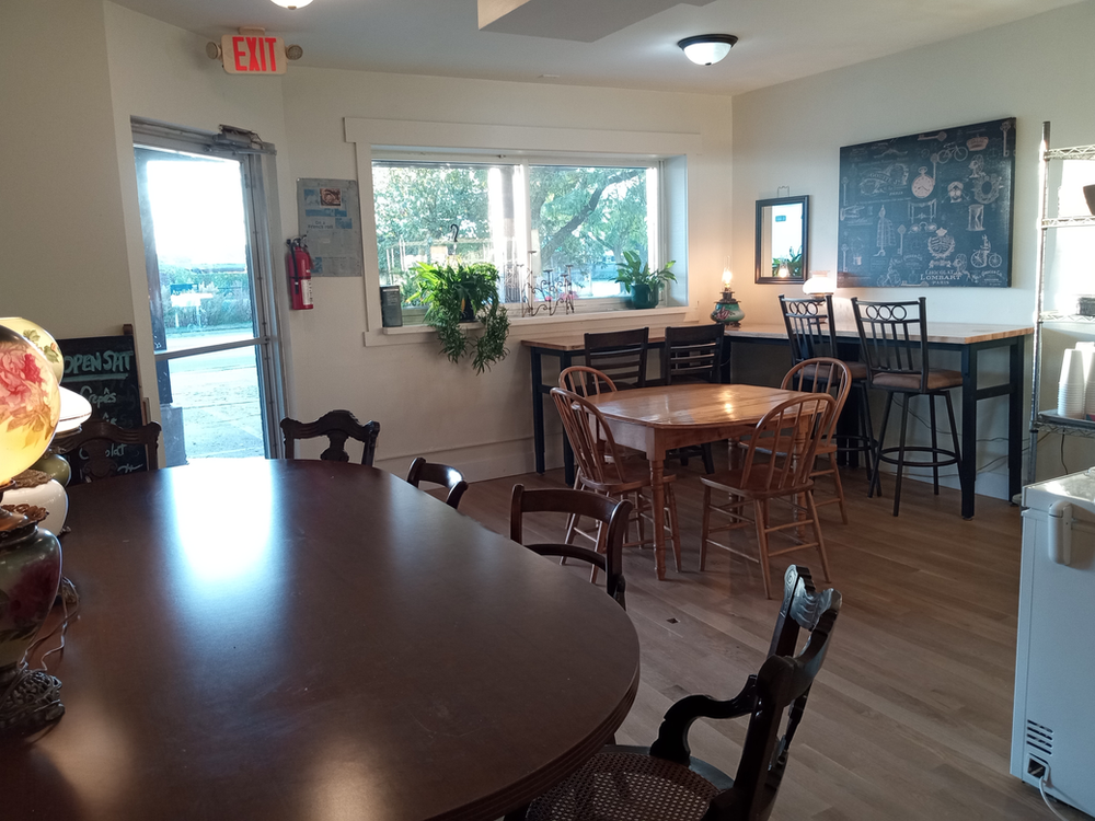 A room with tables and chairs and an exit sign