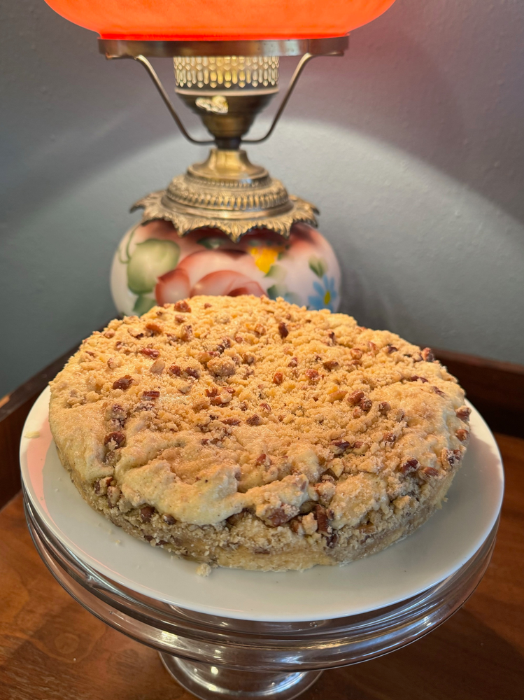 A pie on a plate with a lamp in the background.