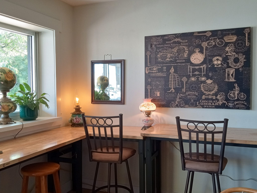 A room with a table and chairs and a painting on the wall