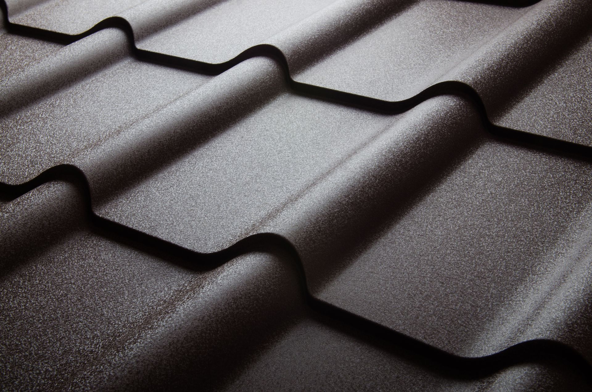 Close-up of a brown textured metal roof with curved tile-like design.