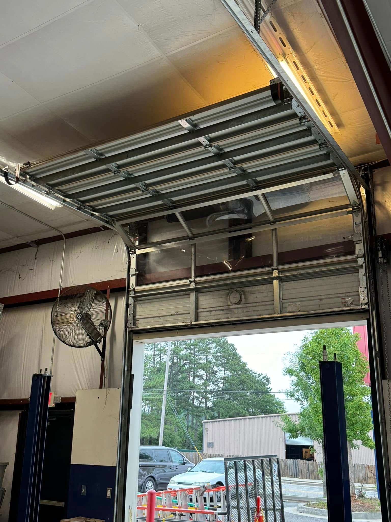 Open garage door, showing vehicles outside.